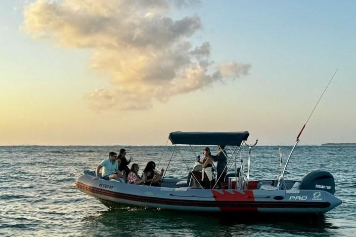 a man riding on the back of a boat in the water